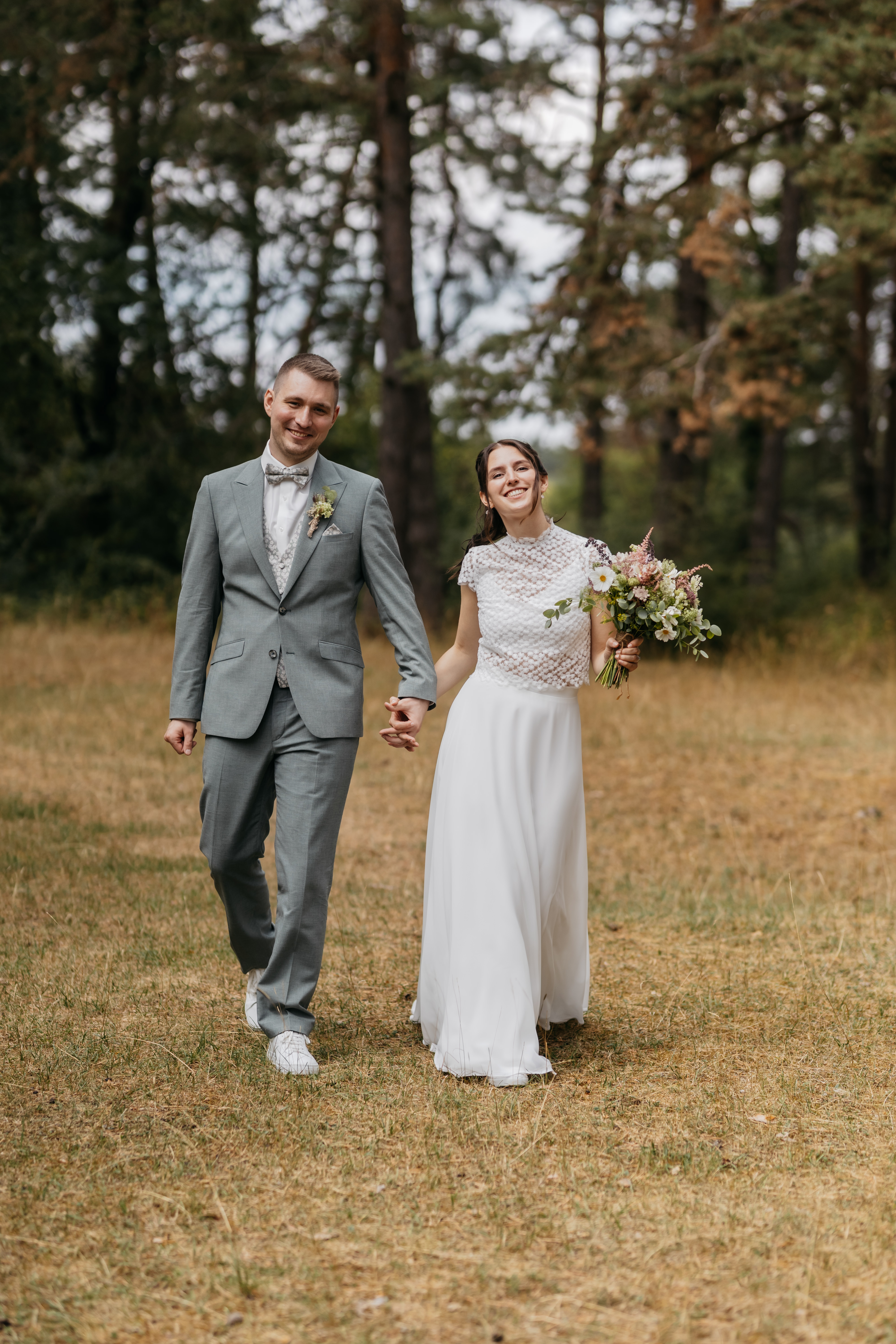 Hanna und Darius spazieren Hand in Hand durch den Wald