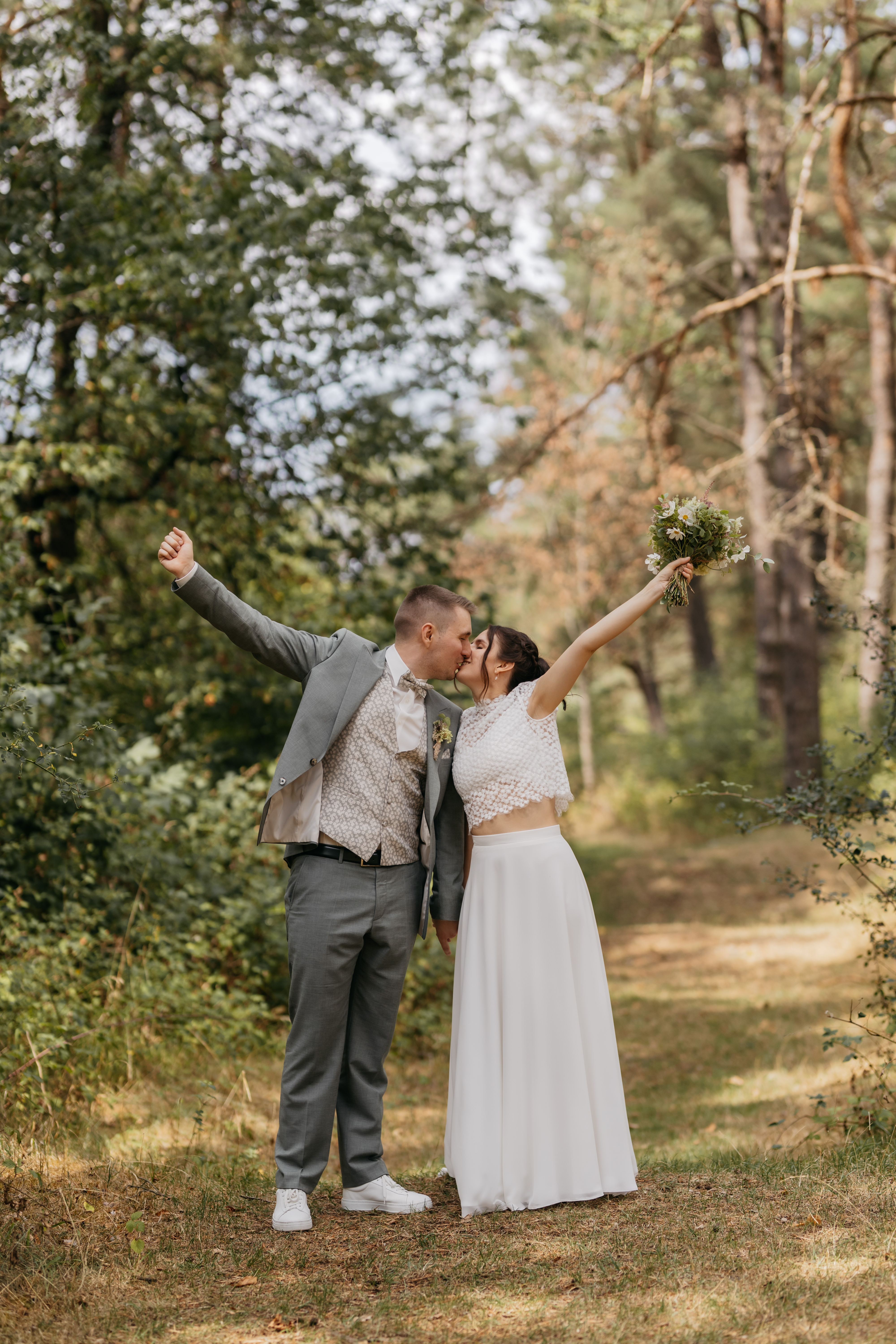 Hanna und Darius küssen sich mit erhobenem Blumenstrauß